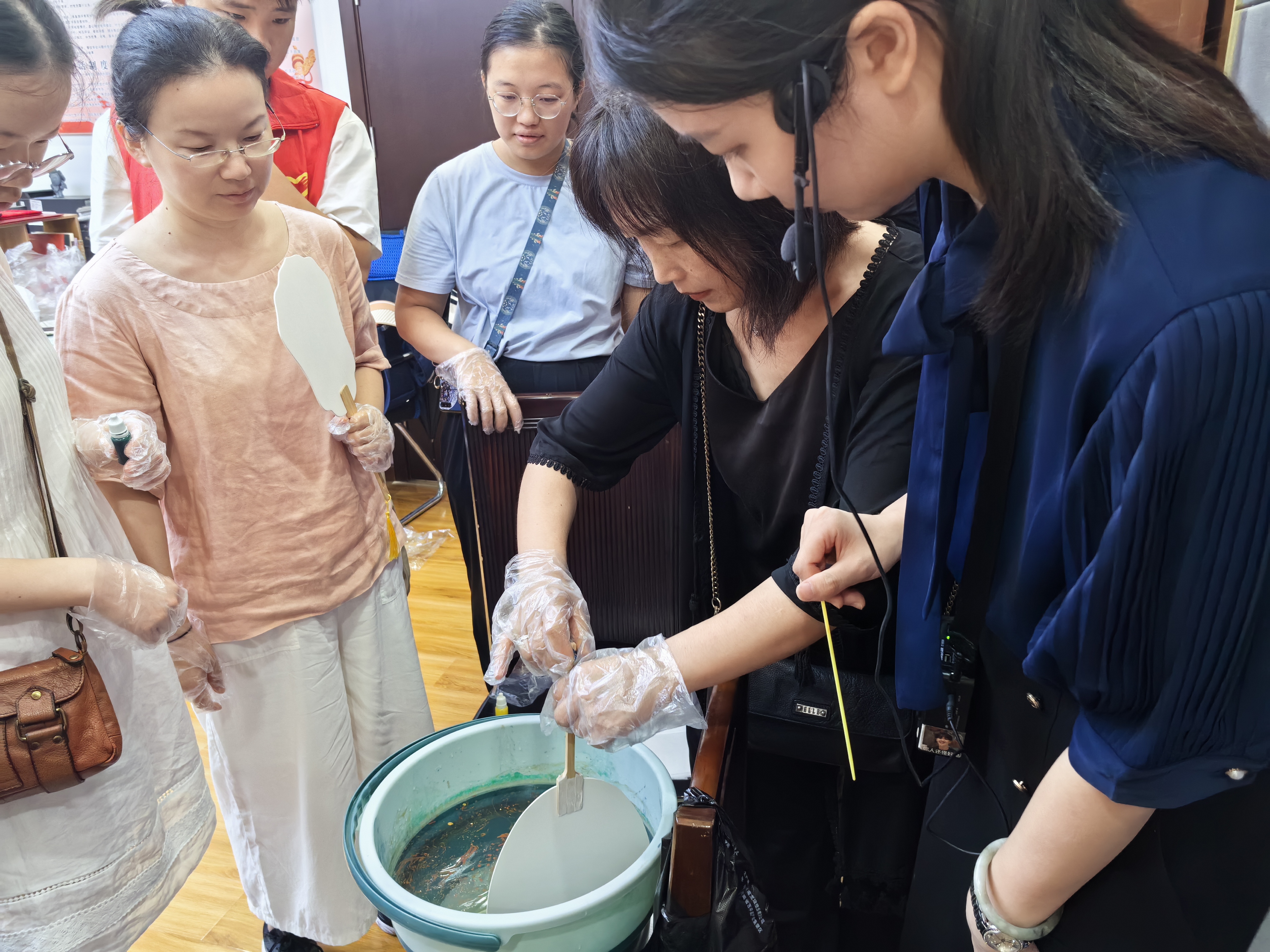 講解員與志愿者引導(dǎo)大家做漆扇1.jpg