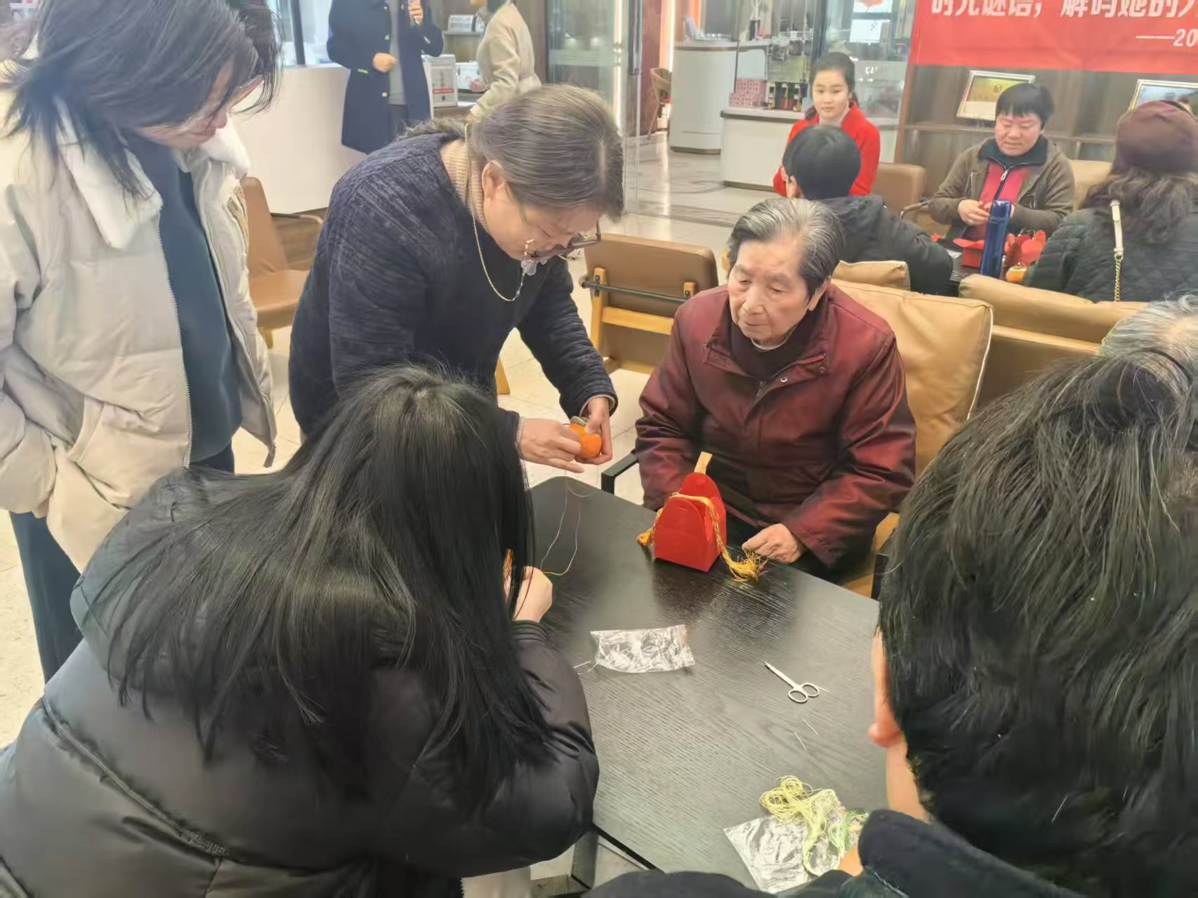 1.汪老師幫助游客完成刺繡.jpg